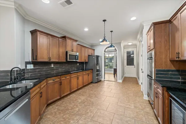 a large kitchen with stainless steel appliances granite countertop a sink and a stove