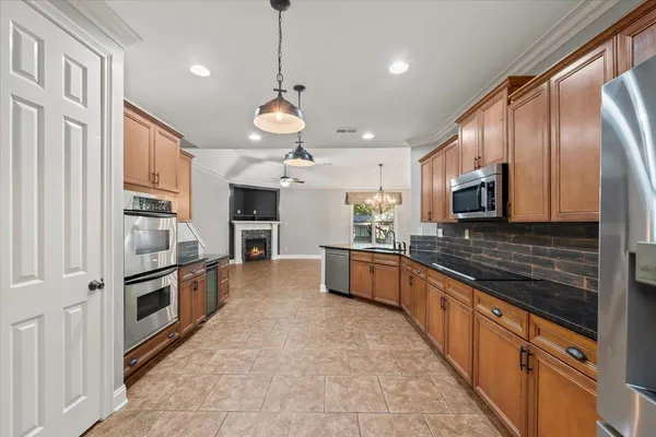 a large kitchen with stainless steel appliances and chandelier