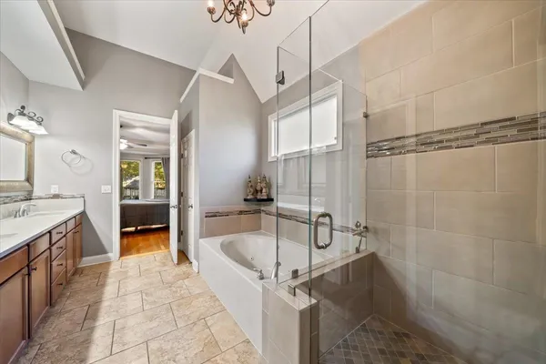 a bathroom with a tub a sink a mirror and a shower