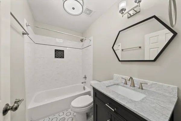 a bathroom with a granite countertop sink mirror vanity and toilet