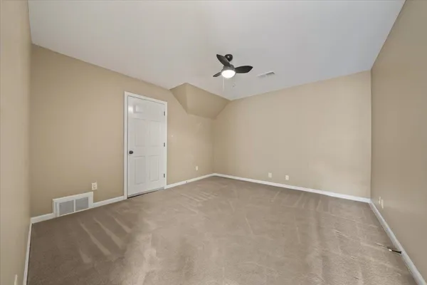 an empty room with a ceiling fan and a window