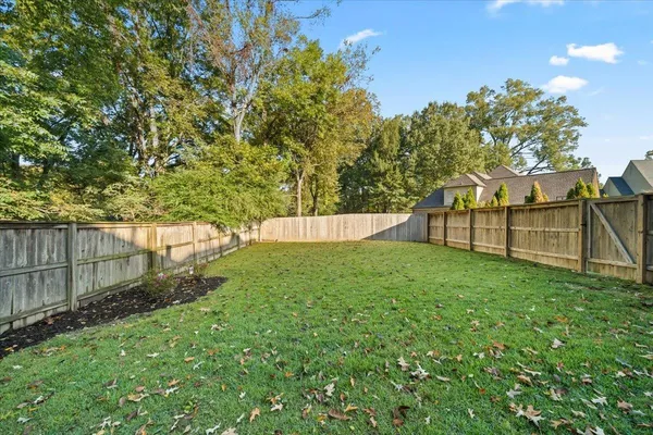 a view of backyard with wooden fence