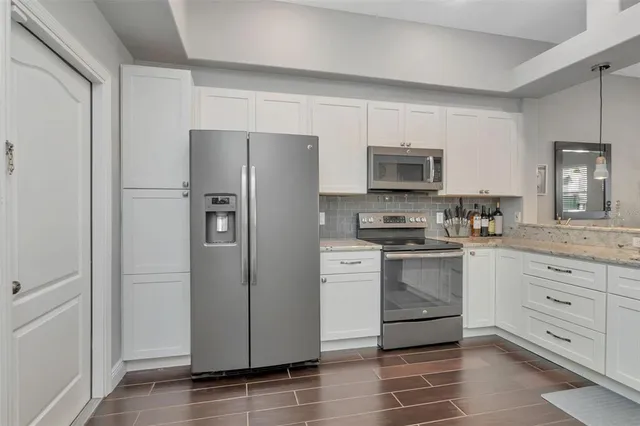 a kitchen with granite countertop white cabinets and white appliances