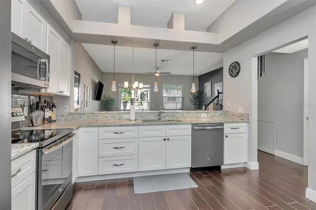 a kitchen with stainless steel appliances granite countertop a stove a sink and a microwave