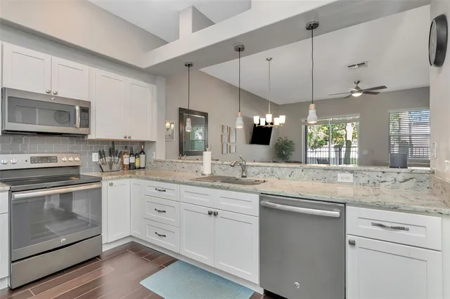 a view of kitchen with a sink cabinets and wooden floor