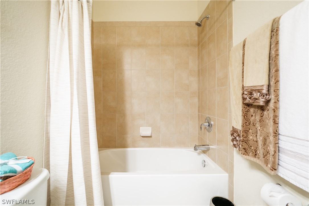 11677 Eros Road Lehigh Acres, FL 33971 - Photo 12 of 27 a bathroom with a bathtub and shower