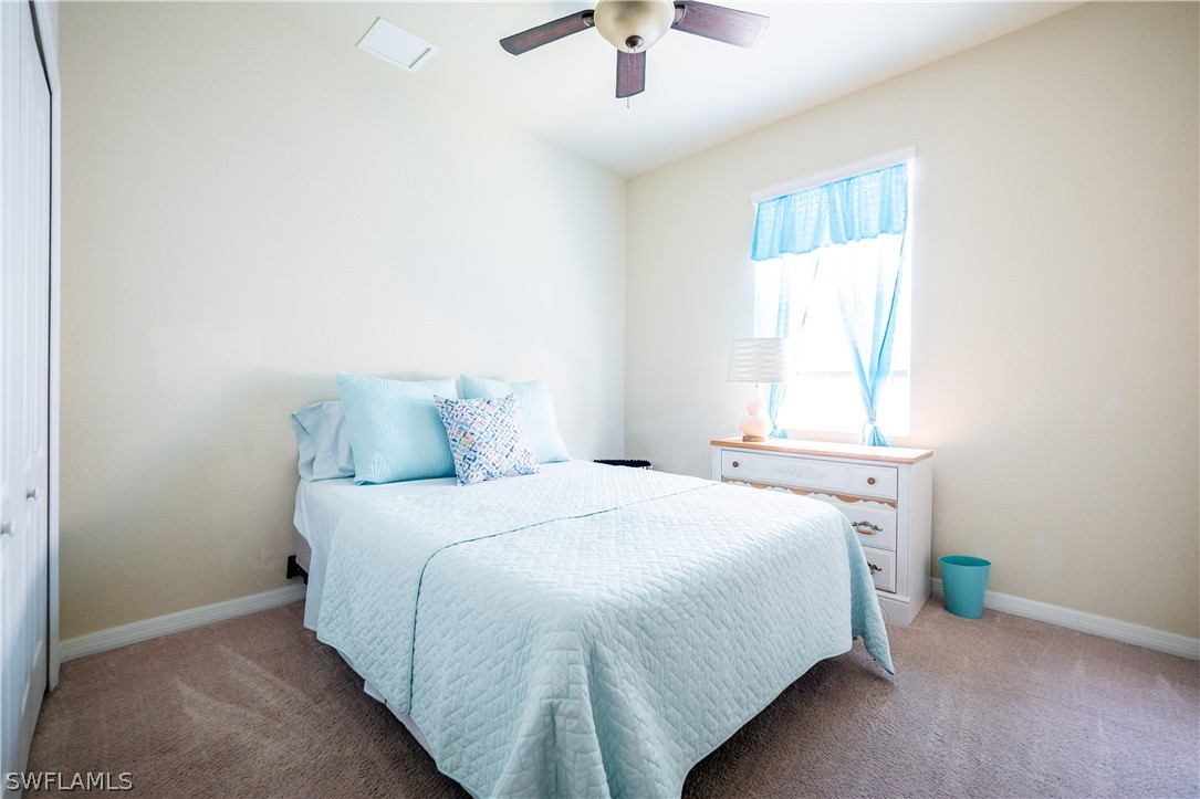 11677 Eros Road Lehigh Acres, FL 33971 - Photo 14 of 27 a bedroom with a bed and a window