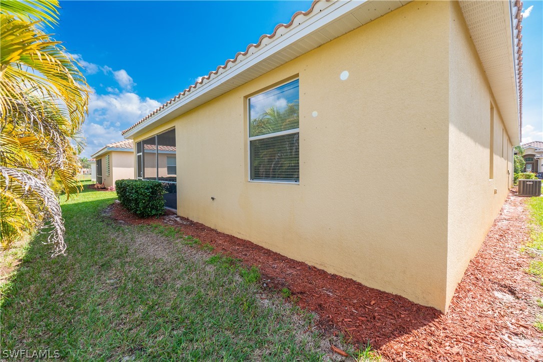 11677 Eros Road Lehigh Acres, FL 33971 - Photo 19 of 27 a view of a backyard with plants and a patio