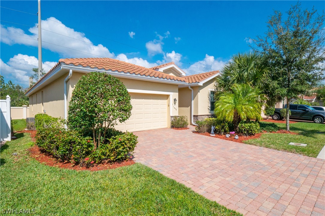 11677 Eros Road Lehigh Acres, FL 33971 - Photo 21 of 27 a front view of a house with garden