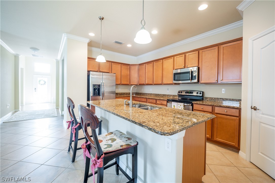 11677 Eros Road Lehigh Acres, FL 33971 - Photo 5 of 27 a kitchen with stainless steel appliances granite countertop a sink a stove a refrigerator cabinets and living room view
