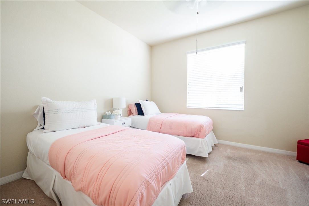 11677 Eros Road Lehigh Acres, FL 33971 - Photo 9 of 27 a bedroom with two beds and a window