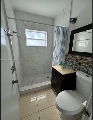 a bathroom with a sink toilet a mirror and shower