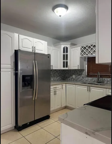 a kitchen with stainless steel appliances granite countertop a refrigerator and a stove