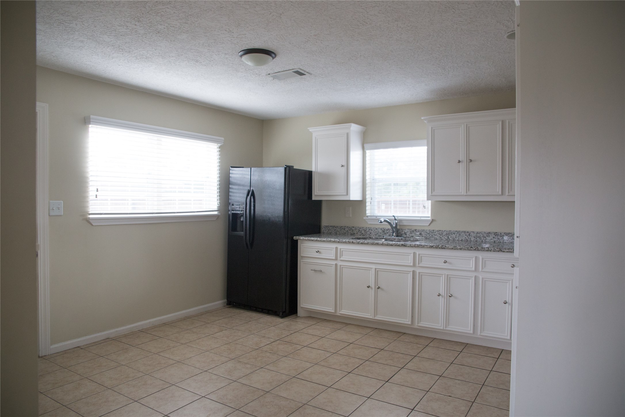 16947 Avenue A Channelview, TX 77530 - Photo 5 of 12 a kitchen with granite countertop white cabinets and refrigerator