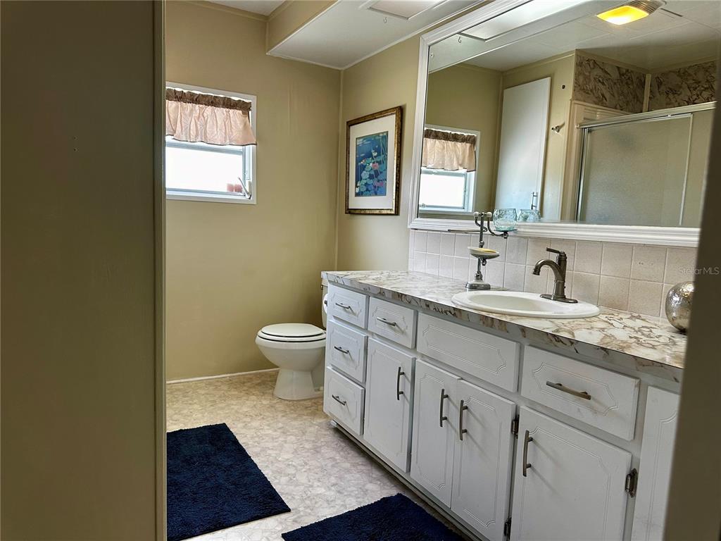 1100 South Belcher Road, Unit 454 Largo, FL 33771 - Photo 17 of 61 a spacious bathroom with a granite countertop toilet a sink and a mirror