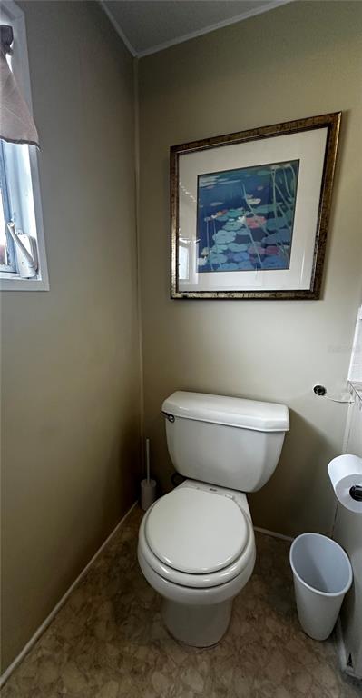 1100 South Belcher Road, Unit 454 Largo, FL 33771 - Photo 20 of 61 a white toilet sitting next to a white walls and a wooden floor