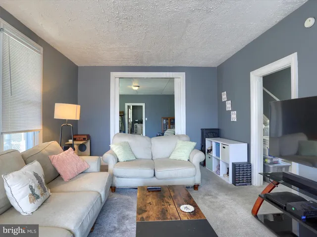 a living room with furniture and a mirror
