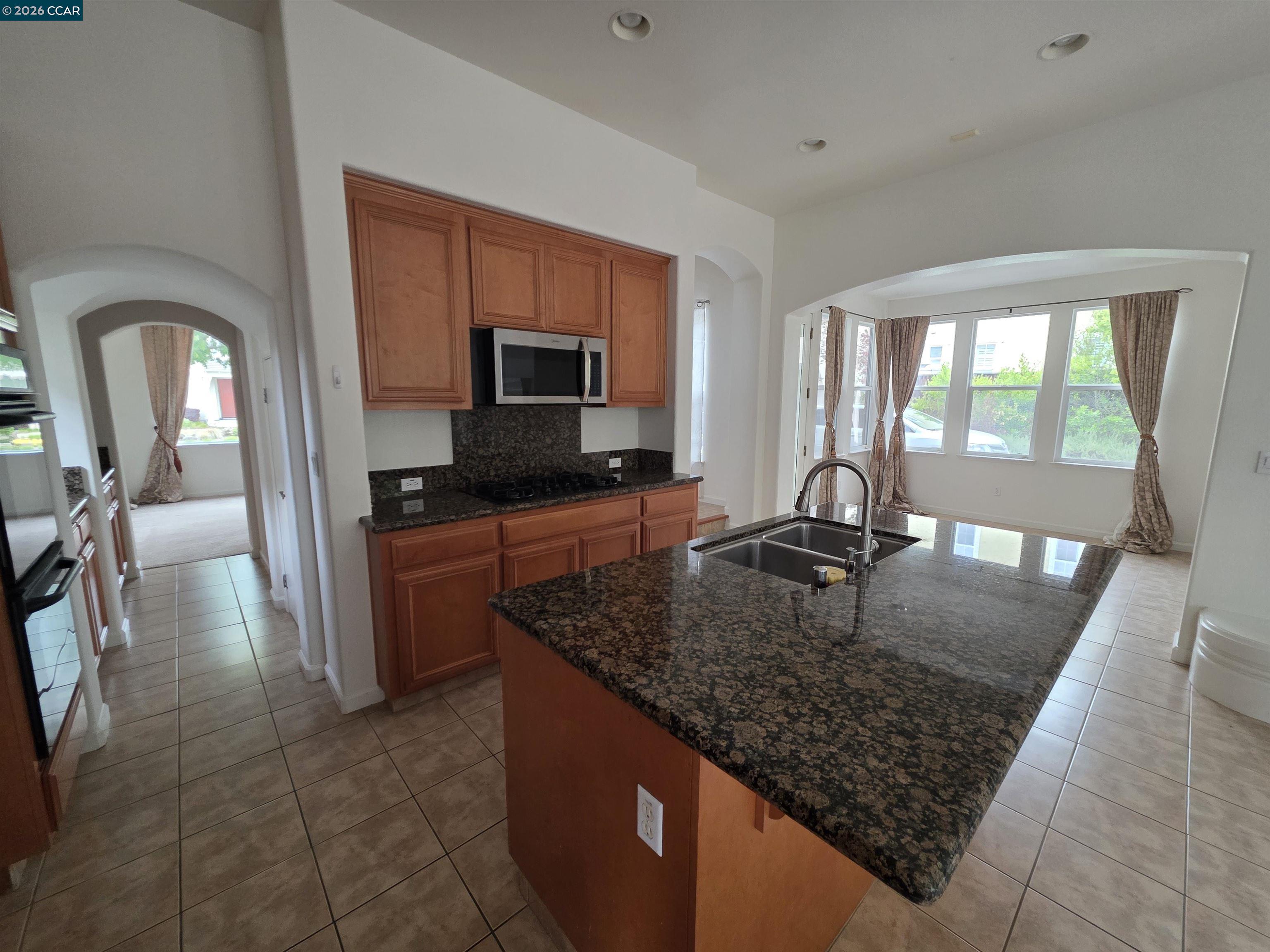 1830 Hollyview Drive San Ramon, CA 94582 - Photo 8 of 36 a kitchen with stainless steel appliances granite countertop a sink a stove microwave and wooden cabinets