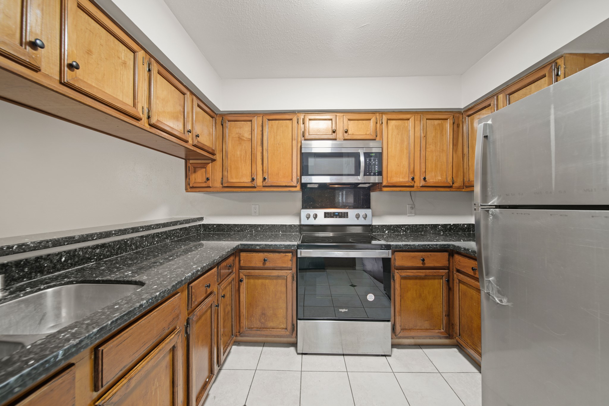 8100 Cambridge Street, Unit 6 Houston, TX 77054 - Photo 13 of 23 a kitchen with stainless steel appliances granite countertop a sink stove and refrigerator