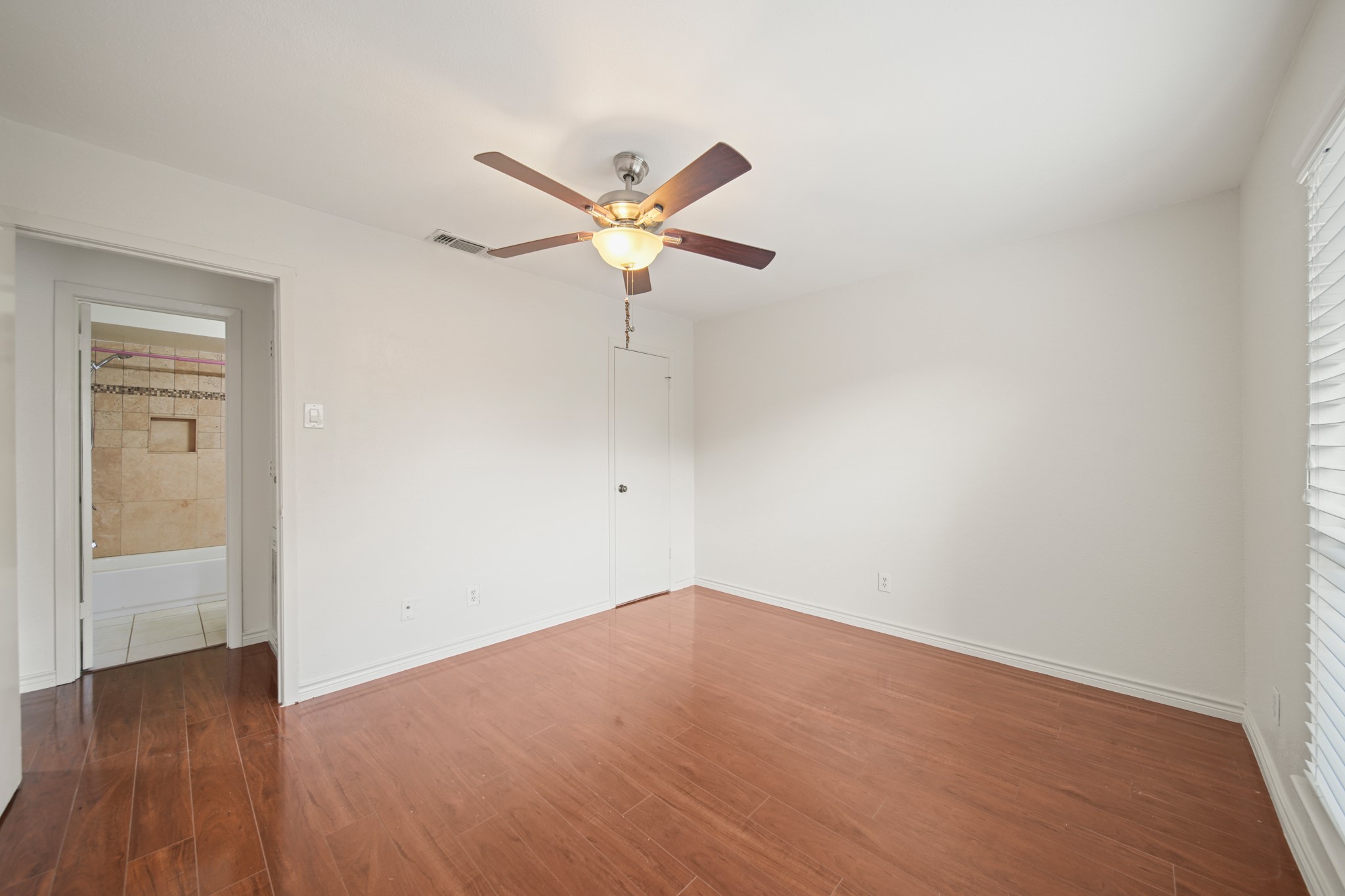 8100 Cambridge Street, Unit 6 Houston, TX 77054 - Photo 19 of 23 a view of a big room with wooden floor and a ceiling fan