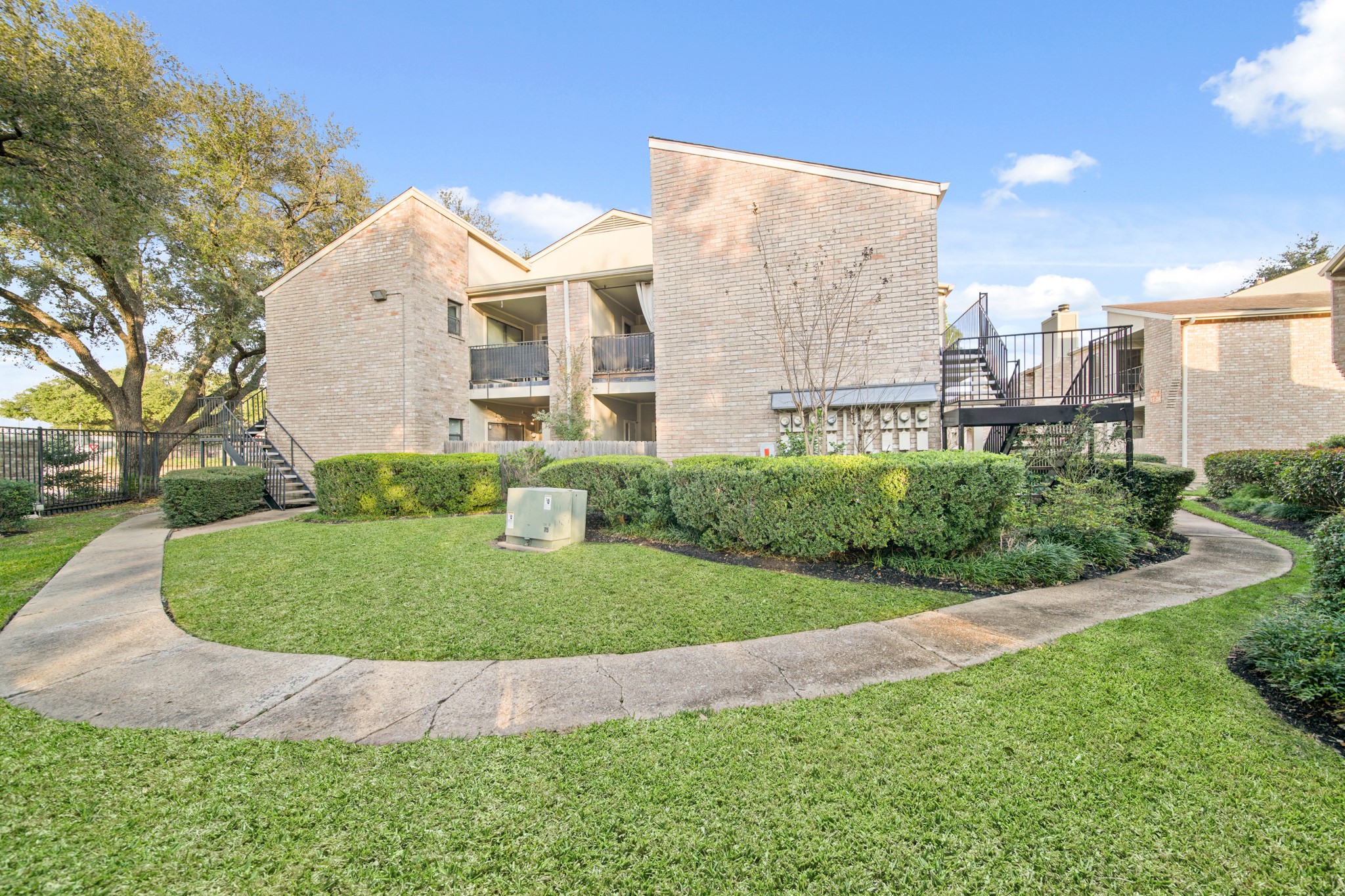 8100 Cambridge Street, Unit 6 Houston, TX 77054 - Photo 2 of 23 a view of a white house with a yard and a fountain