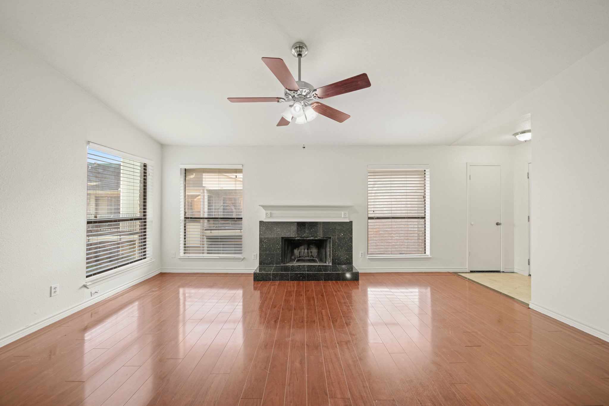 8100 Cambridge Street, Unit 6 Houston, TX 77054 - Photo 6 of 23 wooden floor fireplace and windows in an empty room