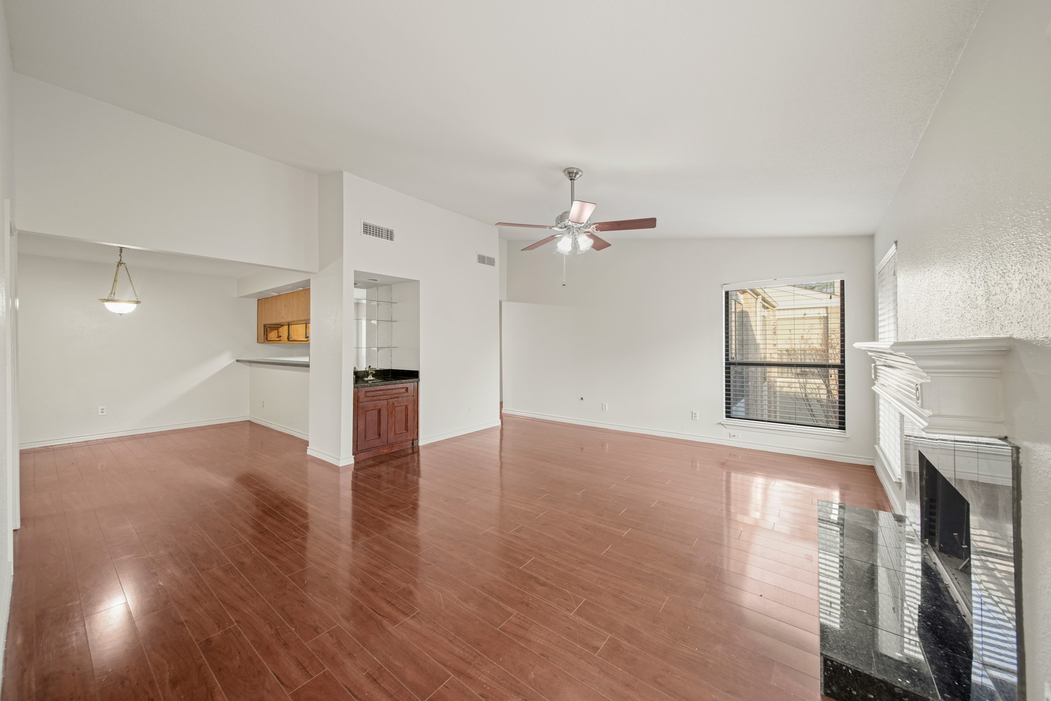 8100 Cambridge Street, Unit 6 Houston, TX 77054 - Photo 9 of 23 a view of an empty room with wooden floor fireplace and a window