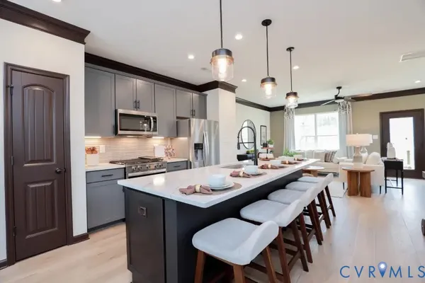 a kitchen with stainless steel appliances a stove a sink a dining table and chairs