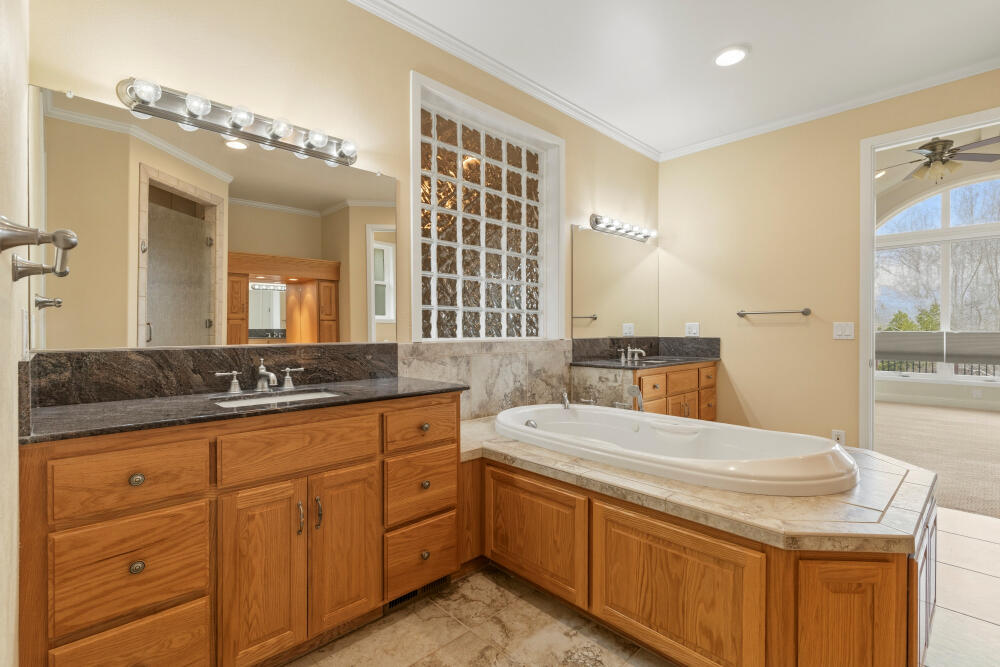 6586 Cooper's Hawk Road Klamath Falls, OR 97601 - Photo 24 of 68 a bathroom with a granite countertop sink a large mirror and a bathtub