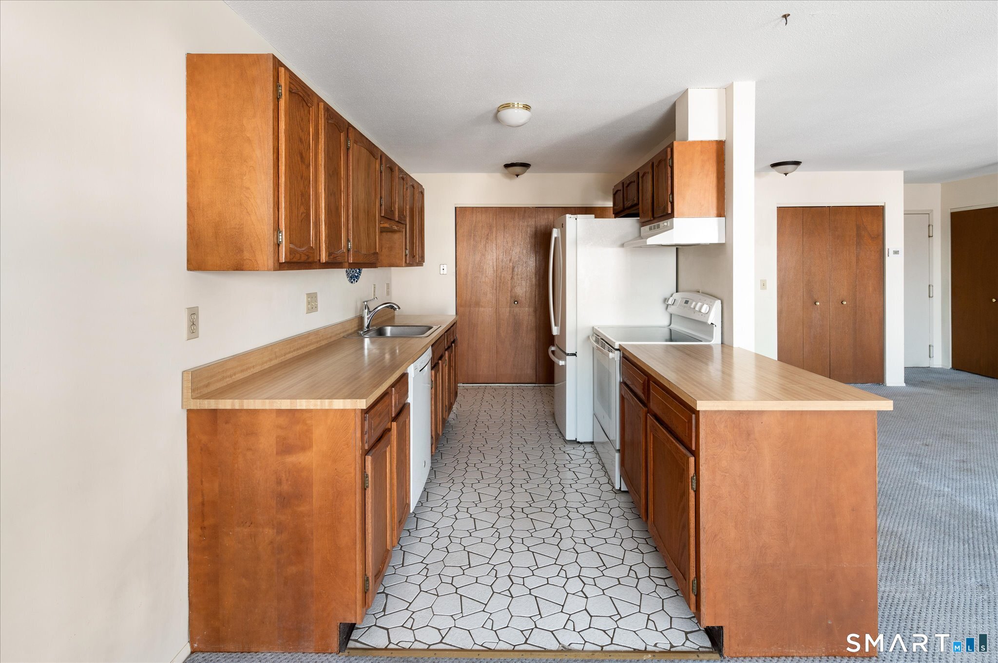 950 Cove Road, Unit B6 Stamford, CT 06902 - Photo 19 of 34 a kitchen with a sink a stove top oven a refrigerator a sink and dishwasher