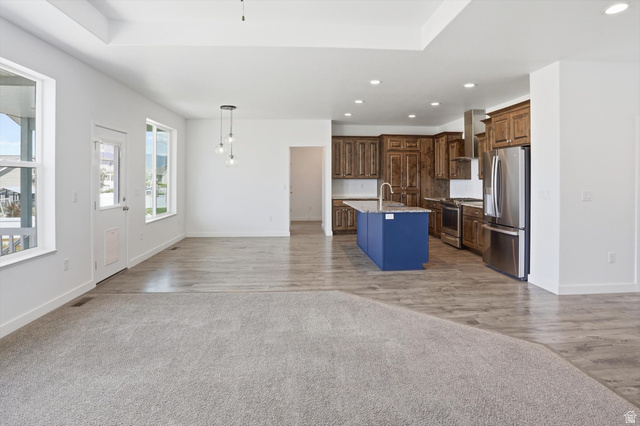 3636 West 910 South Syracuse, UT 84075 - Photo 43 of 70 Open-concept living space featuring wood-finish flooring, recessed lighting, and a tray ceiling