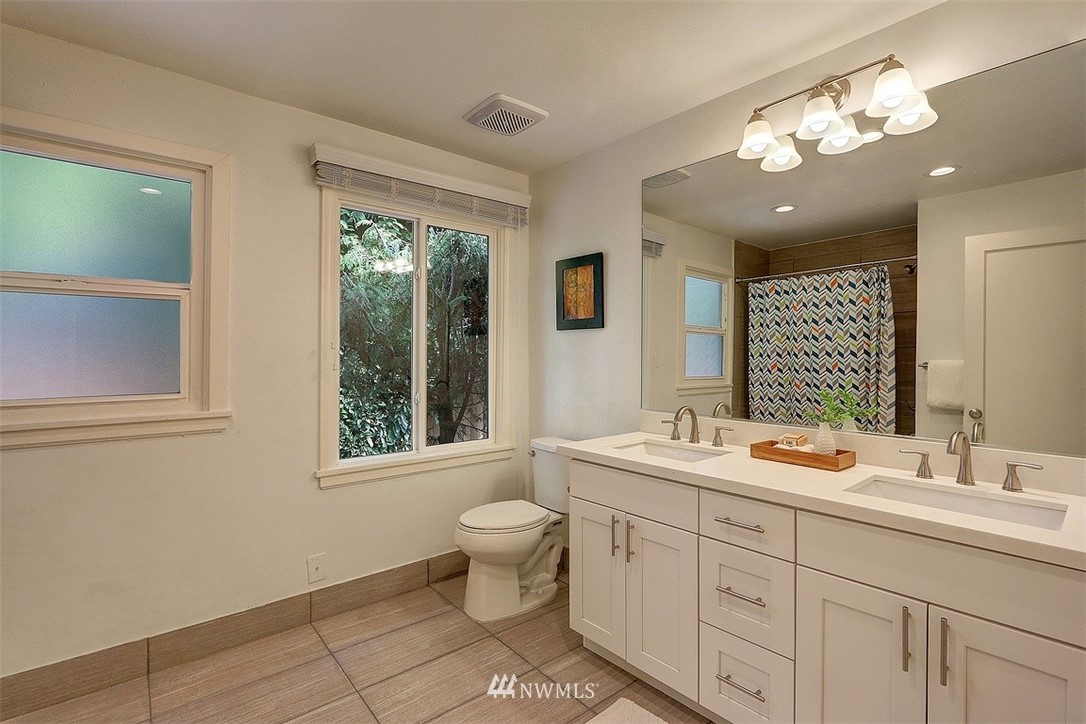 4606 South Adams Street Seattle, WA 98118 - Photo 16 of 29 a bathroom with a toilet a sink and mirror