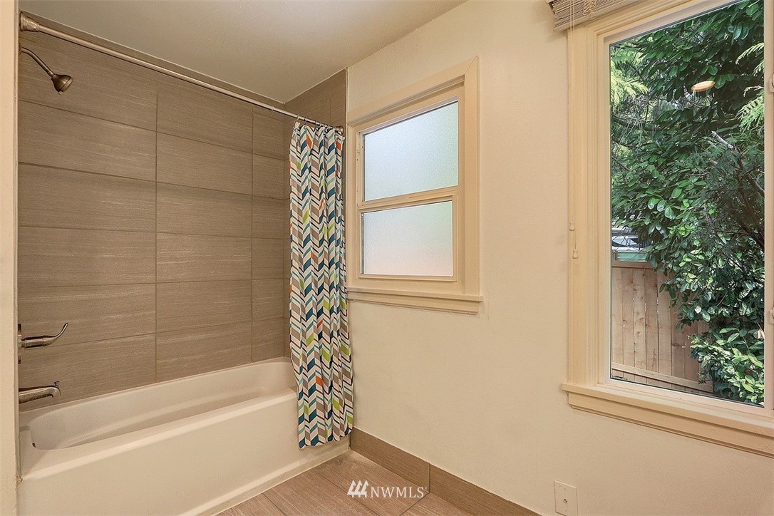 4606 South Adams Street Seattle, WA 98118 - Photo 17 of 29 a bathroom with a bathtub and shower