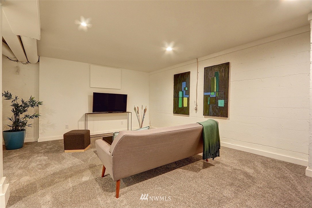 4606 South Adams Street Seattle, WA 98118 - Photo 22 of 29 a living room with a bed furniture and a flat screen tv