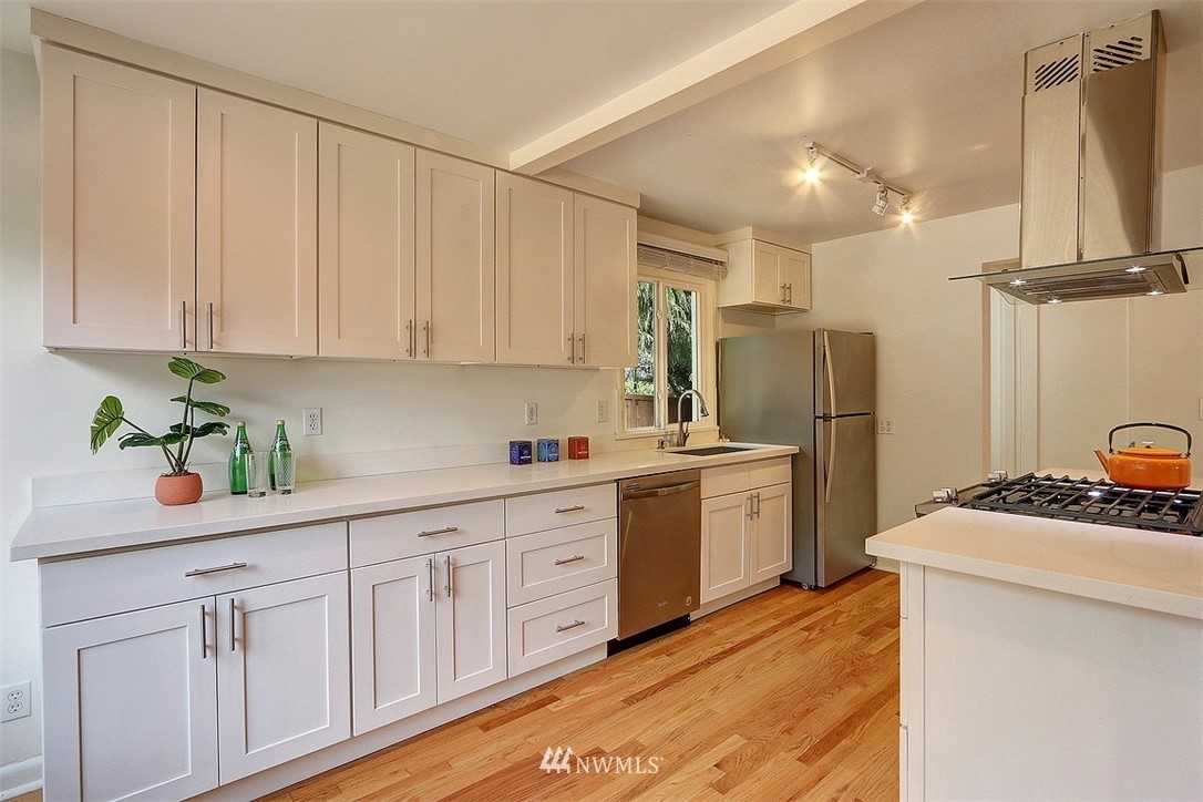 4606 South Adams Street Seattle, WA 98118 - Photo 6 of 29 a kitchen with a sink dishwasher a refrigerator and cabinets