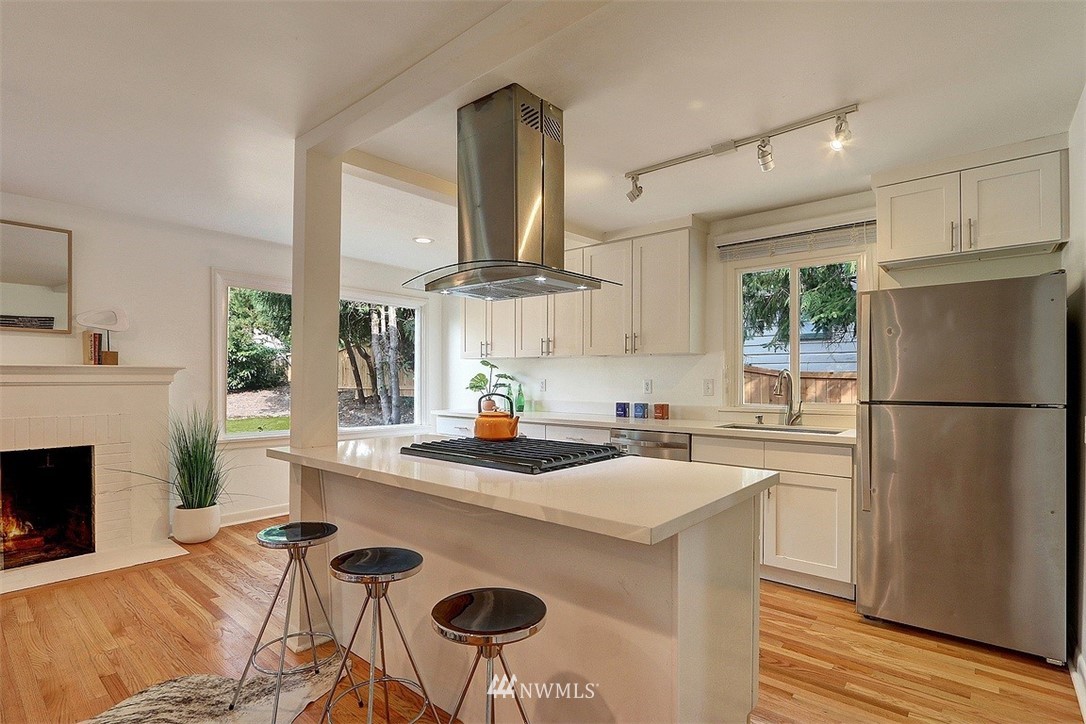4606 South Adams Street Seattle, WA 98118 - Photo 8 of 29 a kitchen with a stove a refrigerator and a fireplace