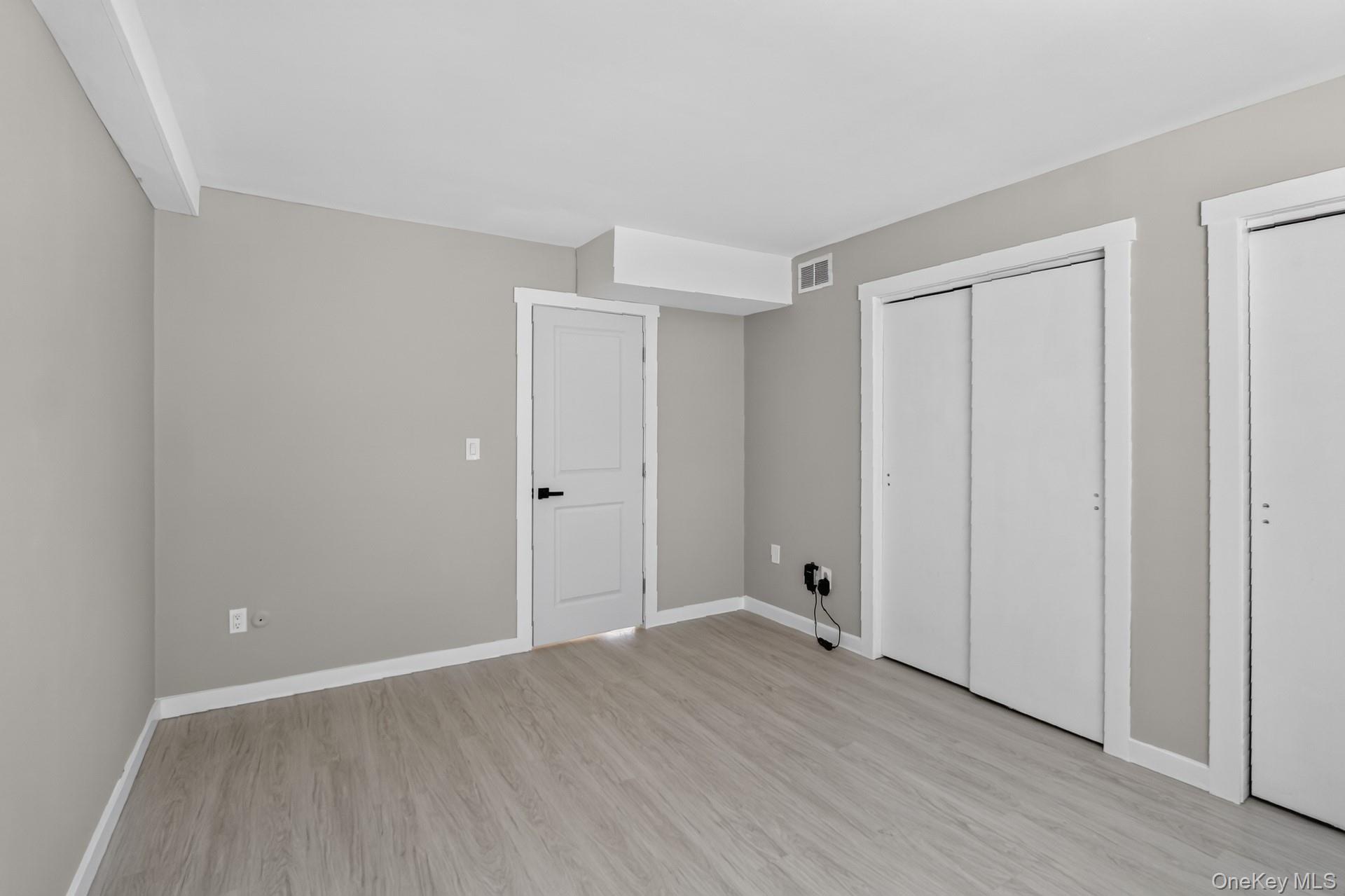 26 Cooper Road, Unit 414 Poughkeepsie, NY 12603 - Photo 11 of 24 Spacious room featuring wood-finish flooring and neutral wall tones