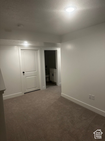 22 South Starlight Lane Mapleton, UT 84664 - Photo 15 of 17 Empty room featuring a textured ceiling and dark colored carpet