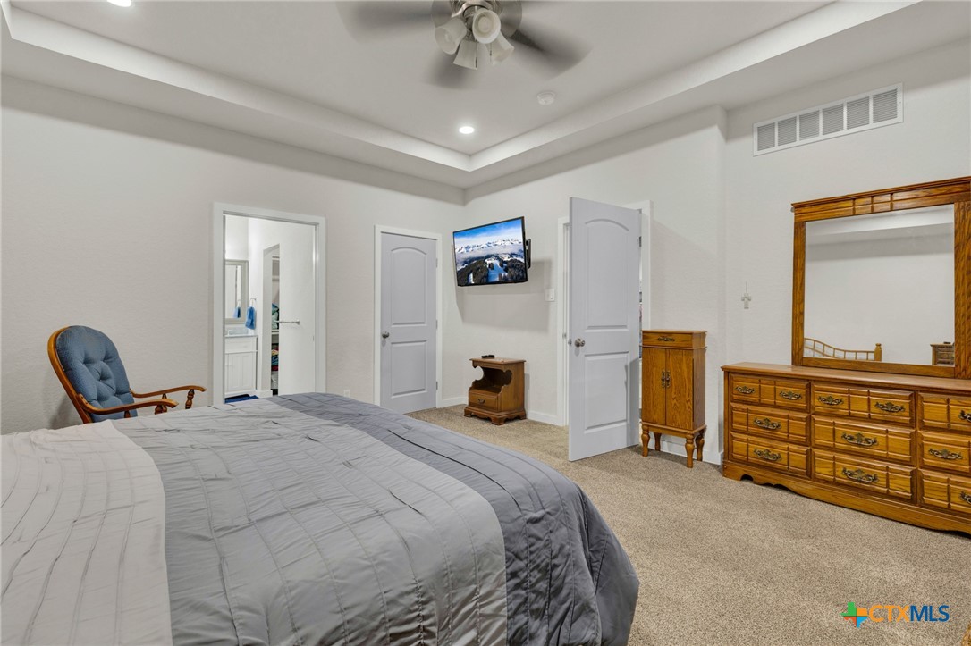 305 Lake Crest Spring Branch, TX 78070 - Photo 11 of 38 a bedroom with a bed and a chandelier
