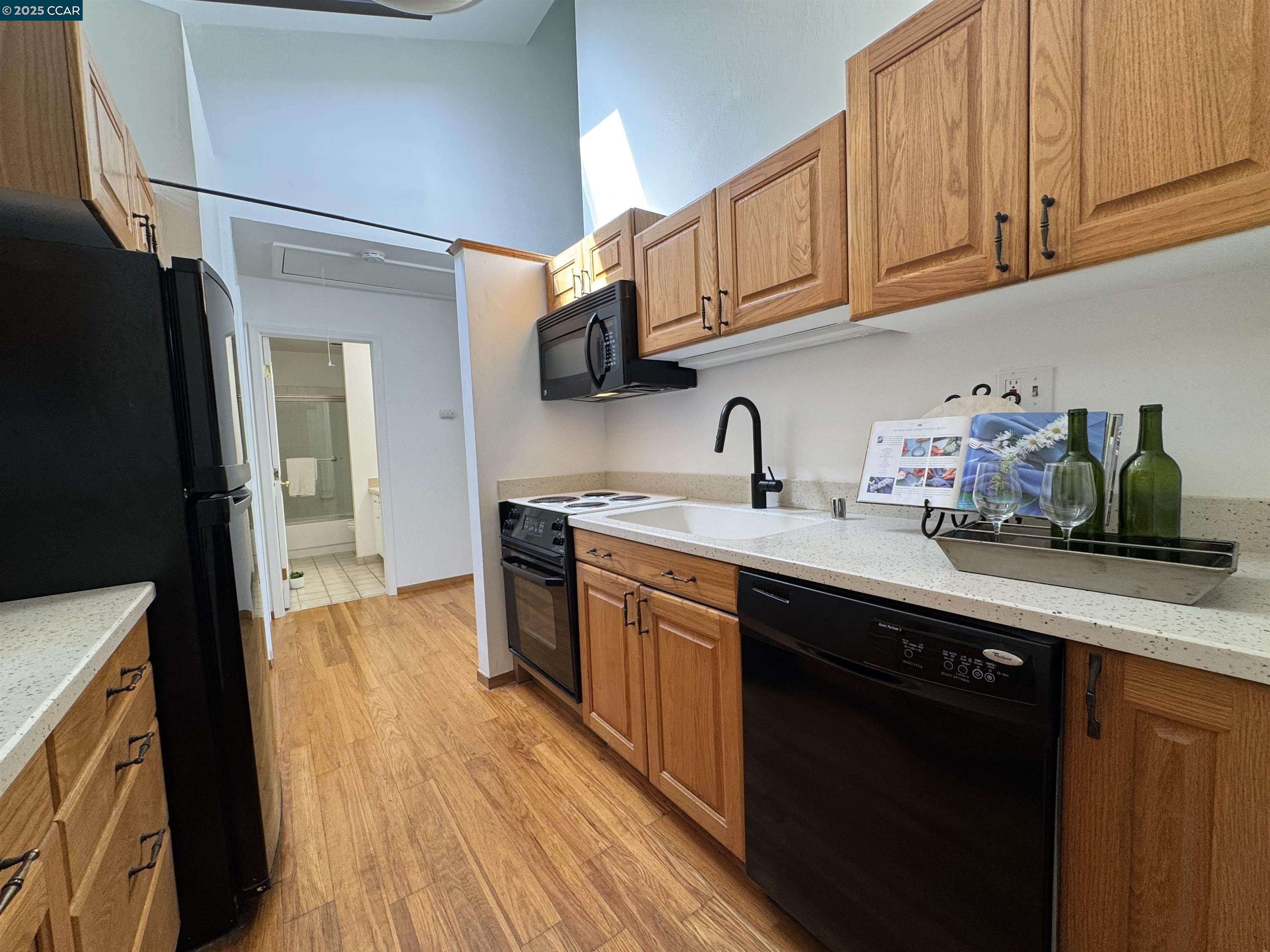 2075 Ascot Drive, Unit 221 Moraga, CA 94556 - Photo 13 of 21 a kitchen with stainless steel appliances granite countertop a refrigerator a sink dishwasher and wooden cabinets with wooden floor