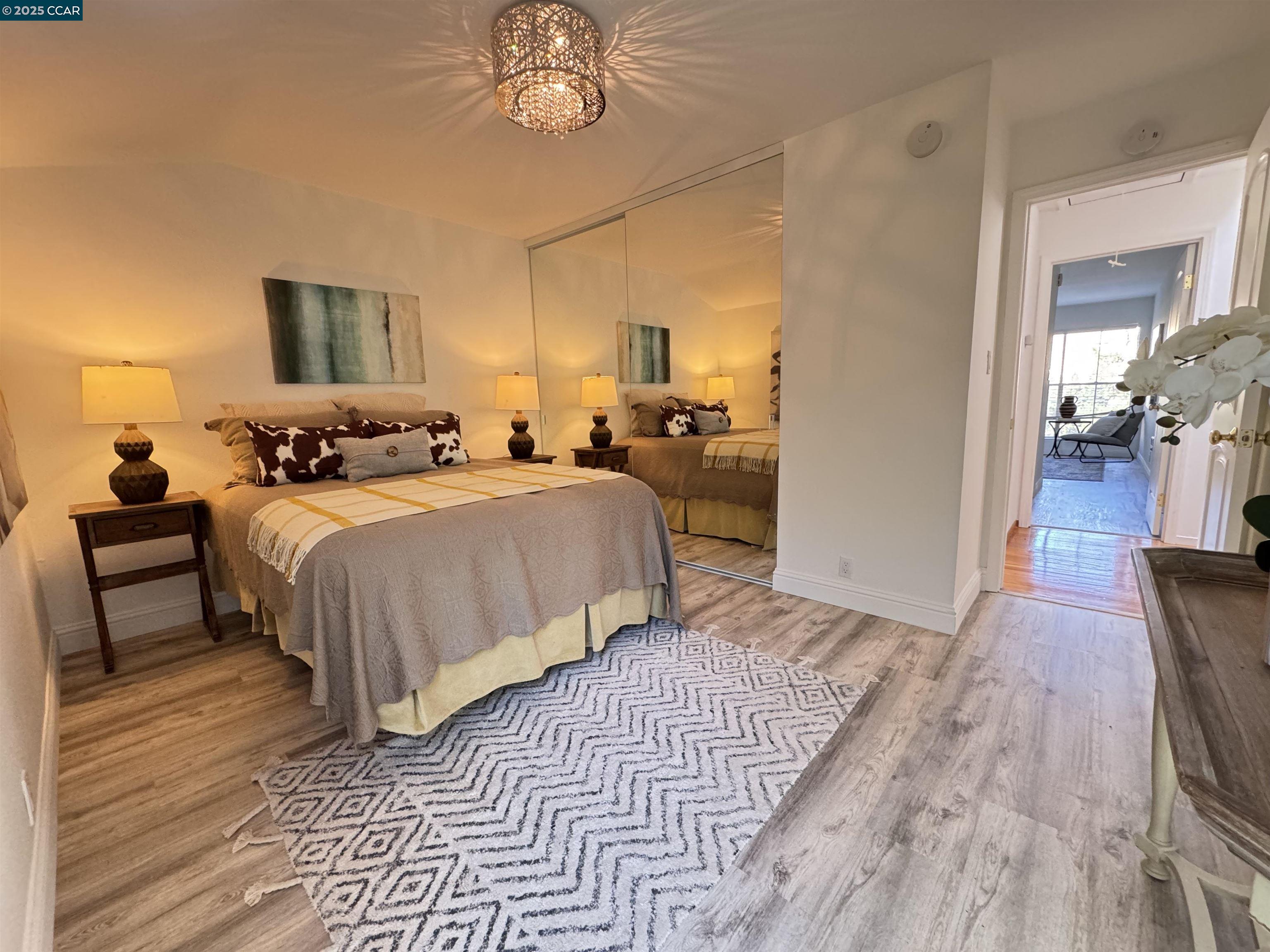 2075 Ascot Drive, Unit 221 Moraga, CA 94556 - Photo 16 of 21 a bedroom with bed and a chandelier