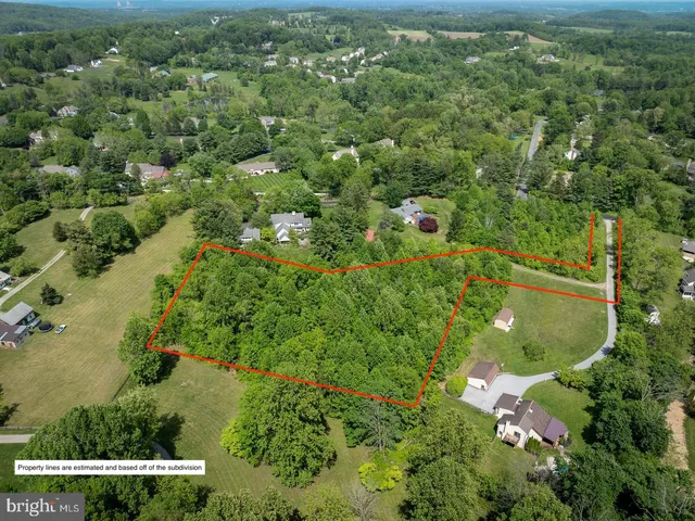 an aerial view of residential houses with outdoor space and trees
