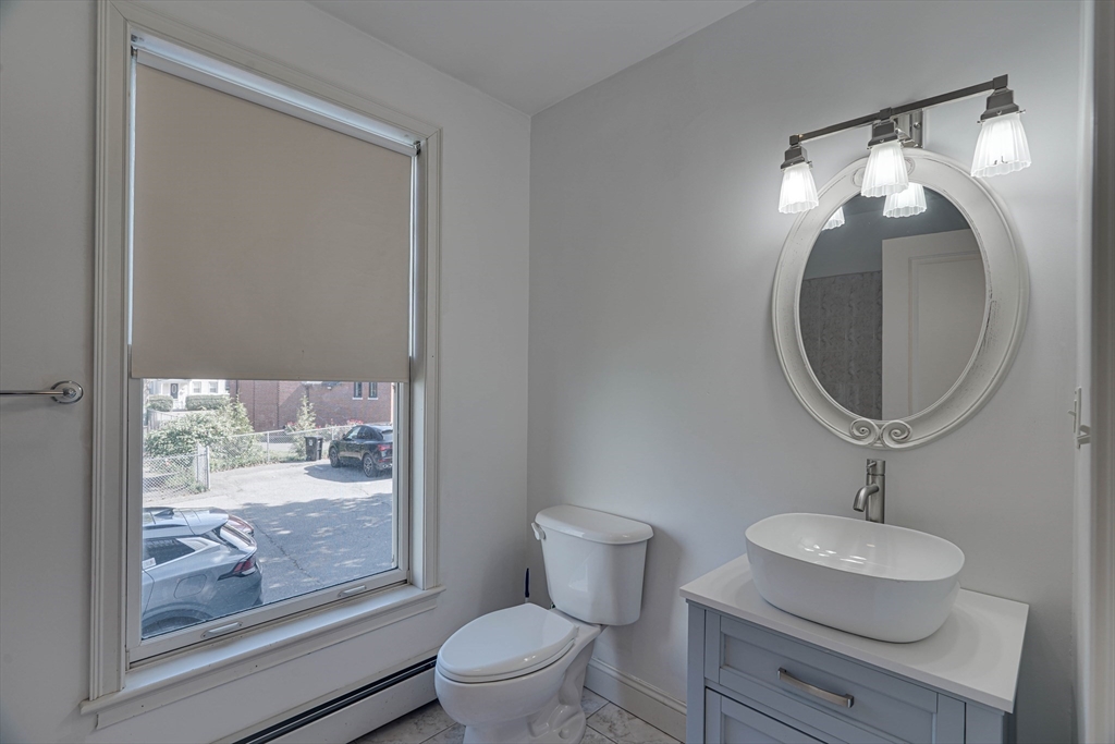 168 Humphrey Street, Unit 2 Swampscott, MA 01907 - Photo 17 of 26 a bathroom with a toilet a sink and mirror