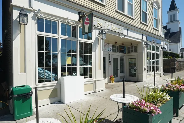 a front view of a building with a garden and sitting area