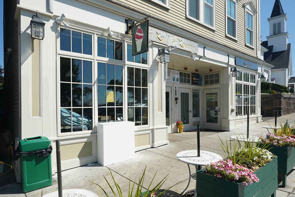 168 Humphrey Street, Unit 2 Swampscott, MA 01907 - Photo 26 of 26 a front view of a building with a garden and sitting area