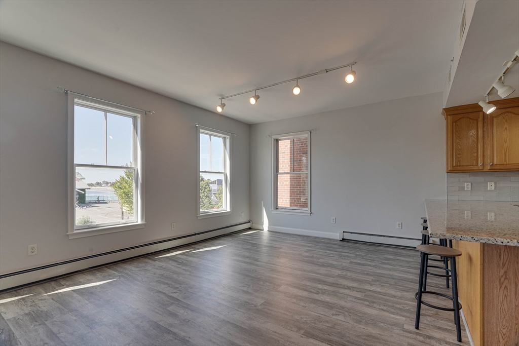 168 Humphrey Street, Unit 2 Swampscott, MA 01907 - Photo 6 of 26 wooden floor in an empty room with a window