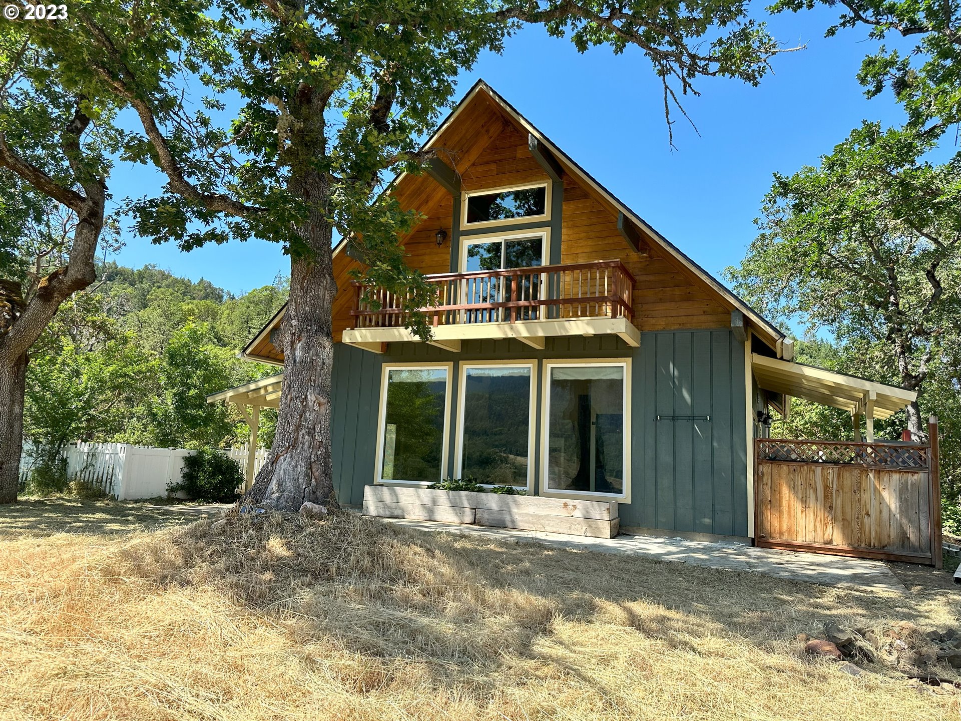 979 Evergreen Ridge Road Riddle, OR 97469 - Photo 31 of 41 a view of a house with a yard plants and large tree
