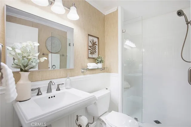 a bathroom with a double vanity sink a large mirror and shower
