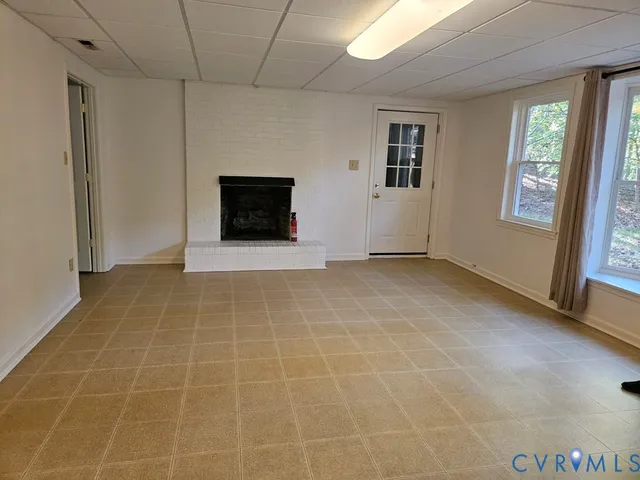 a view of an empty room with a fireplace and a window