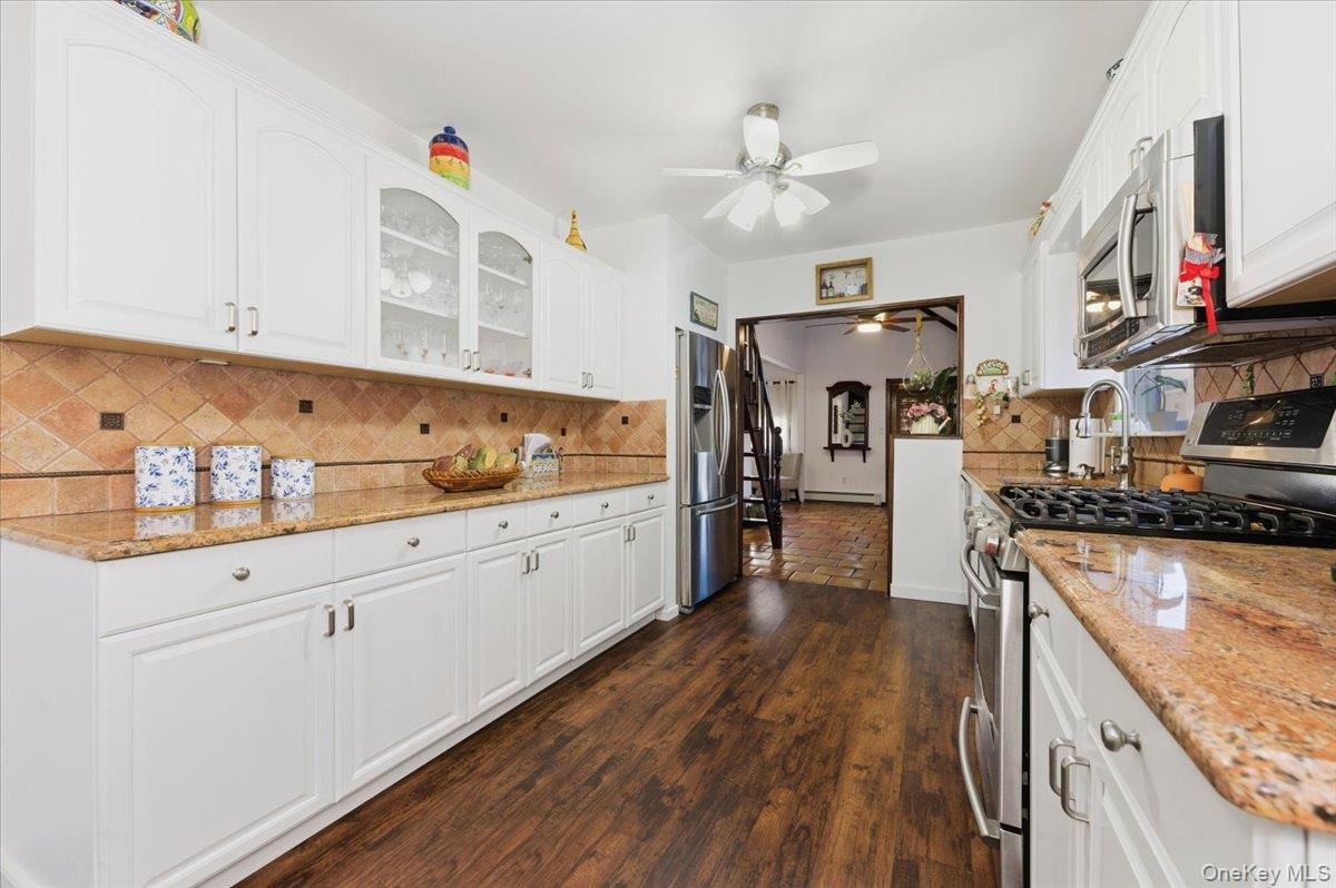 80 Newport Road Island Park, NY 11558 - Photo 7 of 26 a kitchen with stainless steel appliances granite countertop a sink dishwasher stove and refrigerator with wooden floor